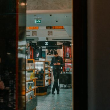 Man in a retail store in Saint Petersburg using a phone. Interior view through glass.
